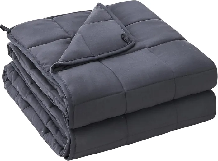 A folded grey quilted weighted blanket with evenly stitched weight compartments.